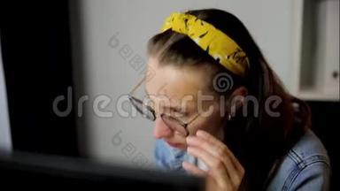 在家庭办公室工作的女人，坐在办公桌前，用严肃而集中的表情看着电脑屏幕。 数据分析
